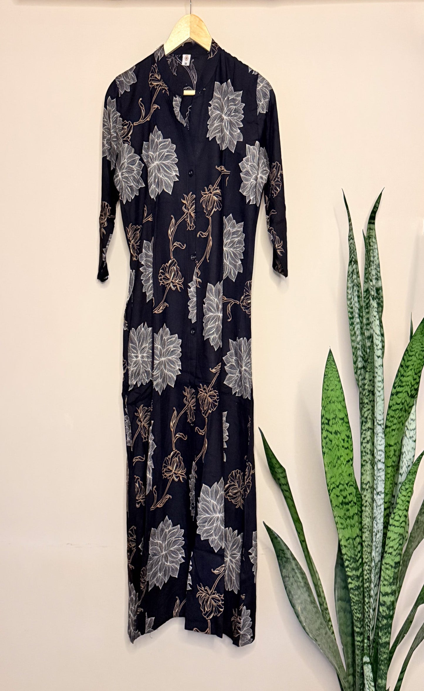 Black coordset with floral pattern on a hanger against a light background