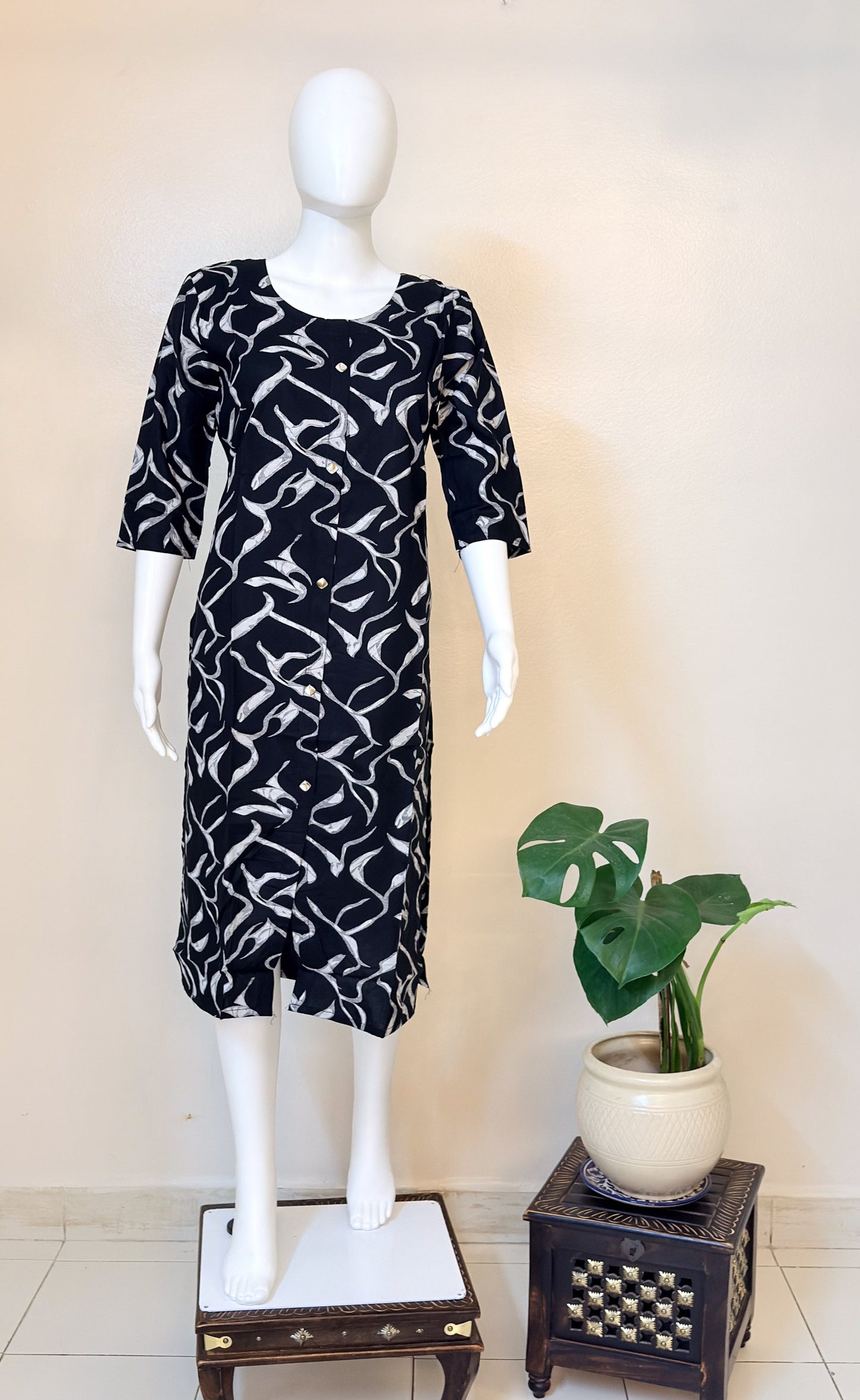 Mannequin wearing a black and white patterned dress.