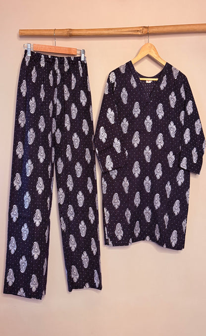 Black and white coordset with white sitara patterns on hangers against a beige background