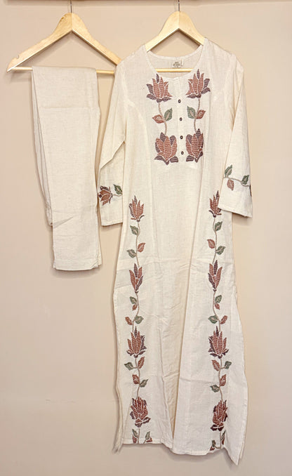 White khadi coordset with floral embroidery on a beige background