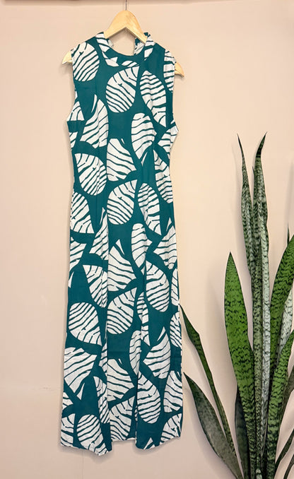 Green and white leaf-patterned coordset on a hanger against a beige wall with a plant.