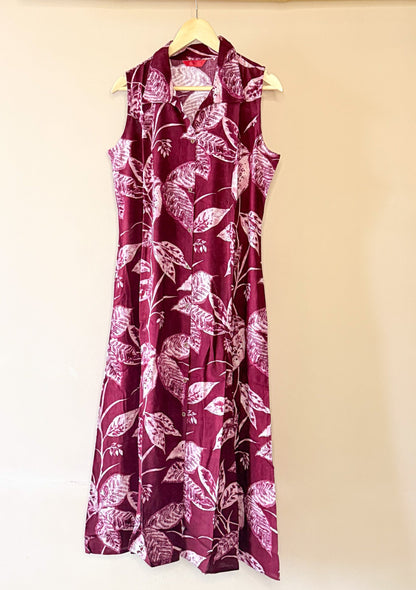 Maroon sleeveless dress with white floral pattern on a beige background