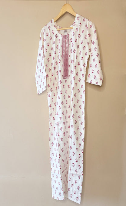 White outfit with pink diamond patterns on a beige background