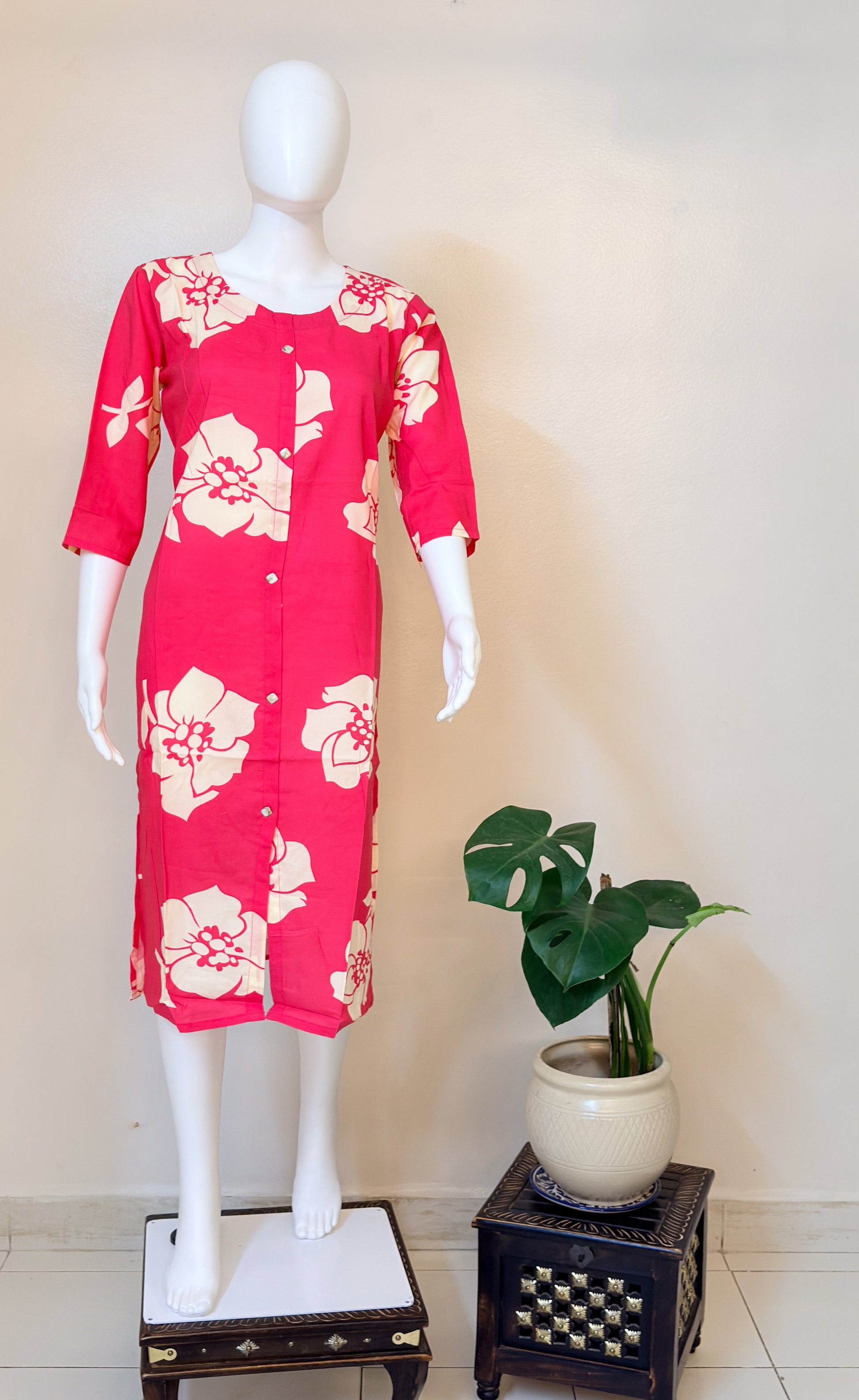 Peach dress with floral pattern on a mannequin against a white background