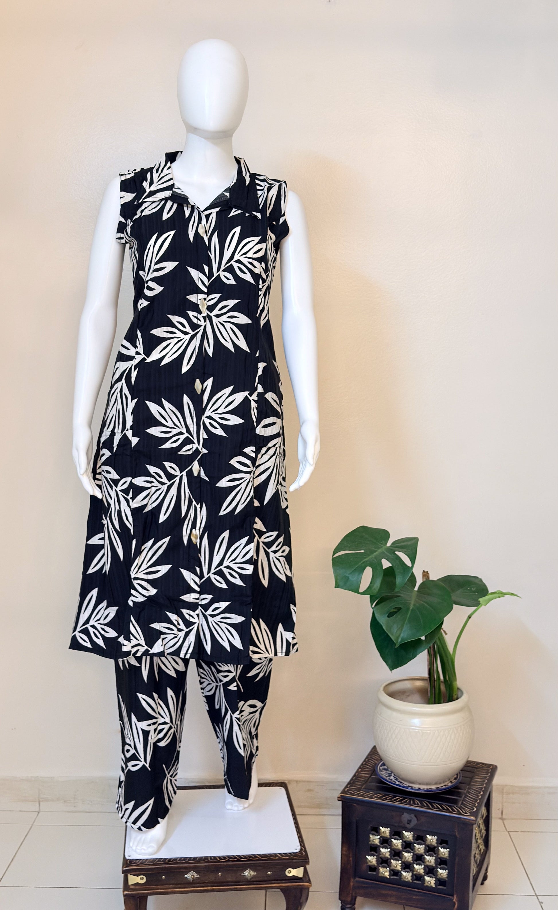 Mannequin wearing a black coordset with white leaf pattern.