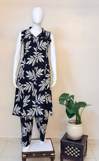 Mannequin wearing a black coordset with white leaf pattern.