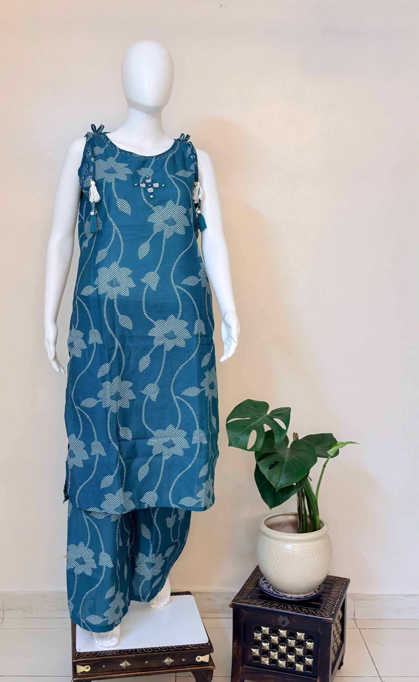 Mannequin wearing a teal green floral coordset with pants 